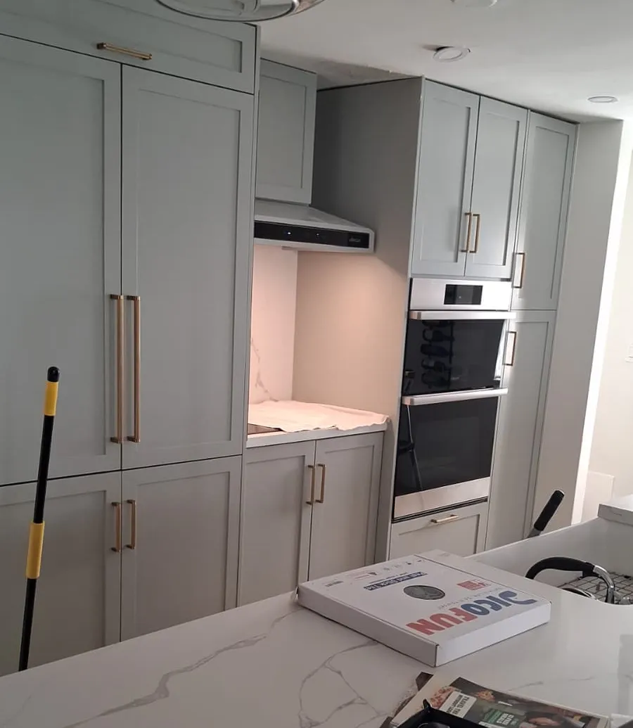 Renovated kitchen from a Butler Construcción project — white painted cabinets and quartz countertops