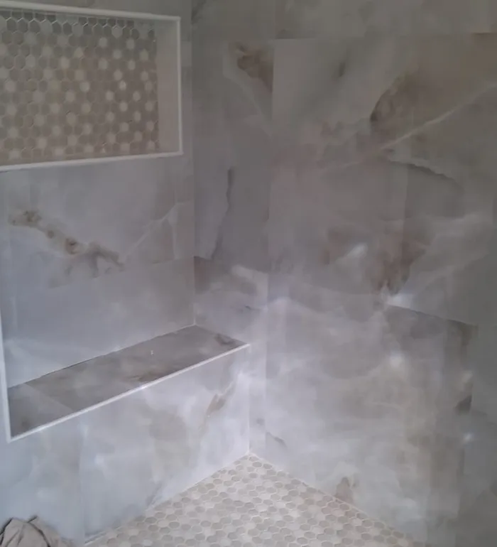 Walk-in shower with marble-look tile and mosaic niche — Butler project