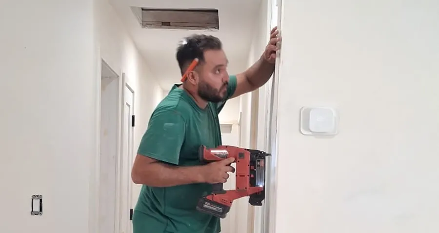 Butler painter cutting in a wall edge during an interior painting project