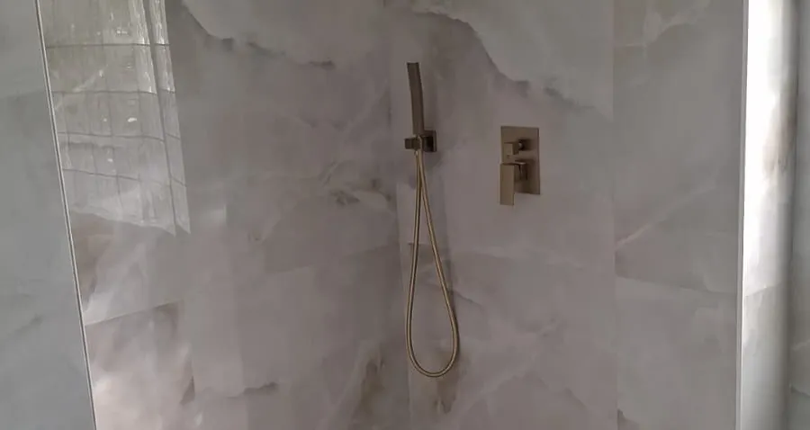 Completed walk-in shower with large-format tile and brass fixtures — Butler project